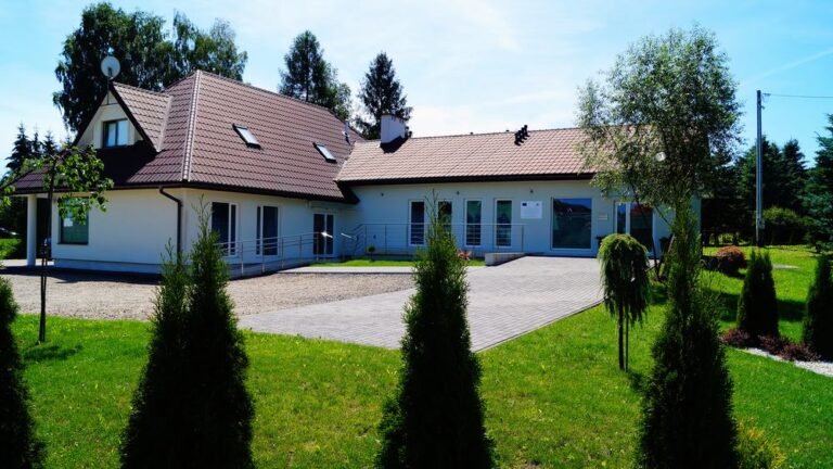 Budynek Kliniki DermaDent w Sanoku otoczony zielenią